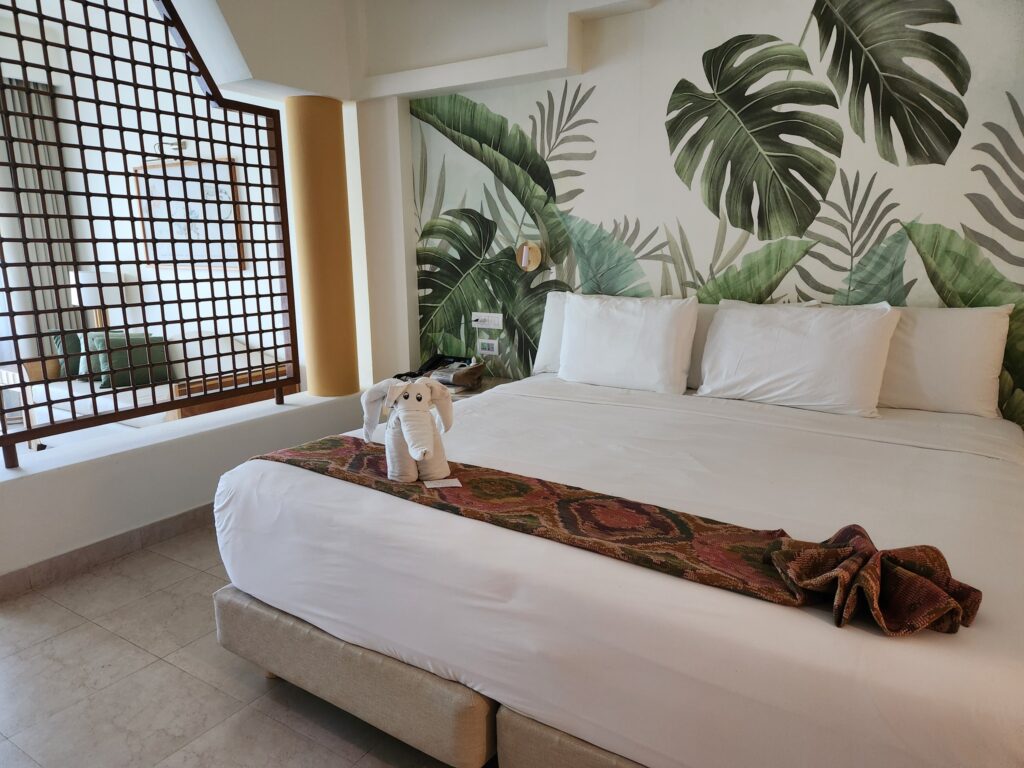 picture of a king size bed and tropical wall paper