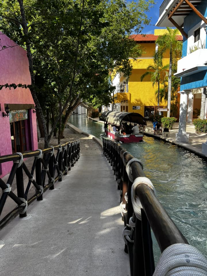 picture of a walkway by a river with a gondola on it