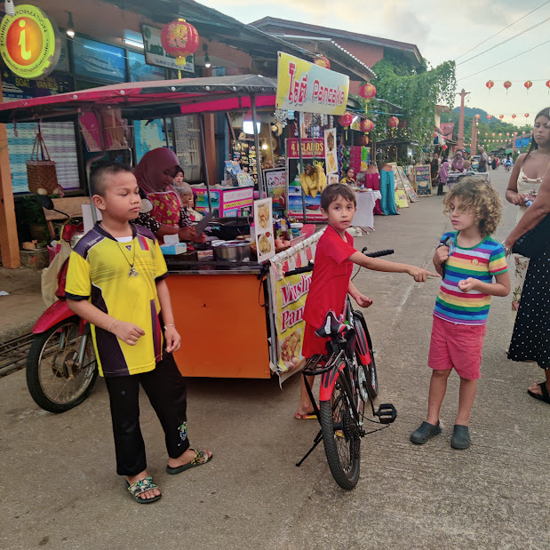 My kids getting Traditional Thai pancakes with their local friends