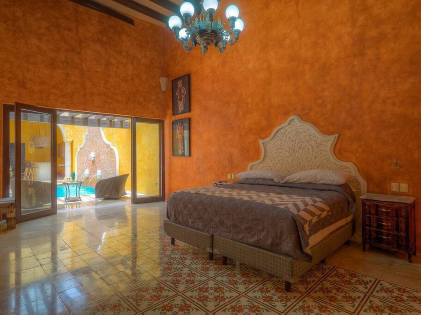 picture of an orange bedroom, with bed and a chandelier