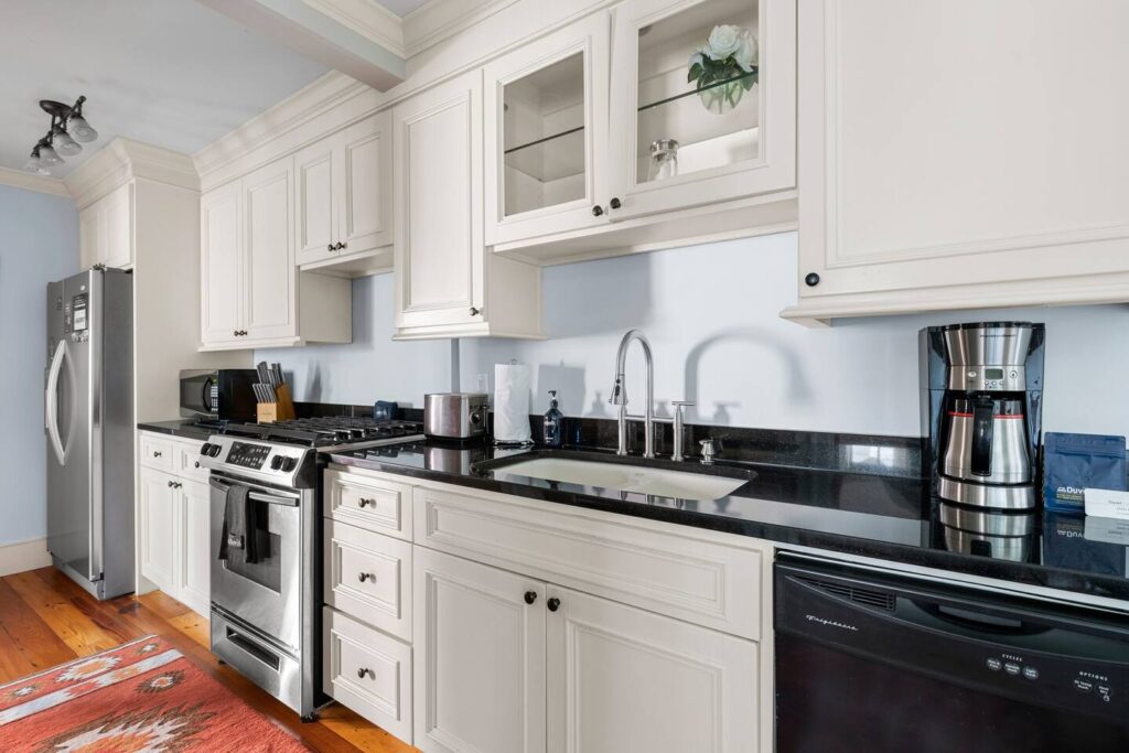 Picture of a kitchen with white cabinets and black appliances