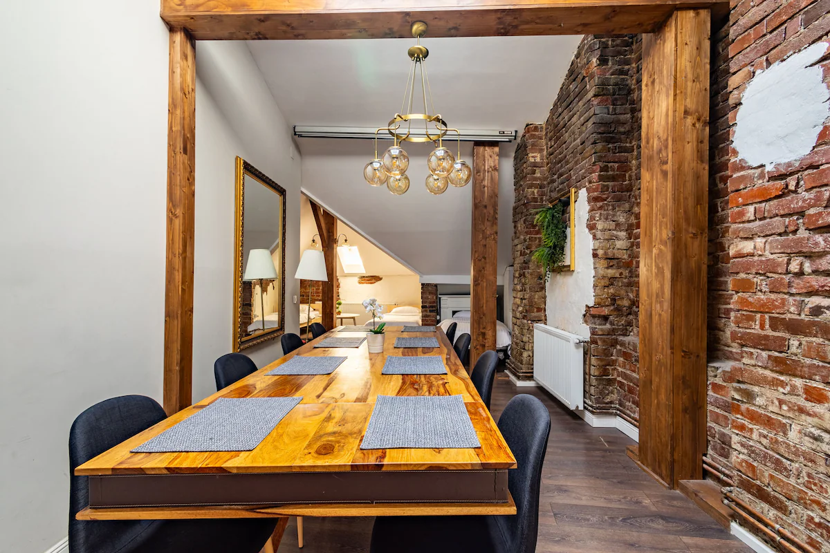 picture of a dining table in a room with exposed brick wall