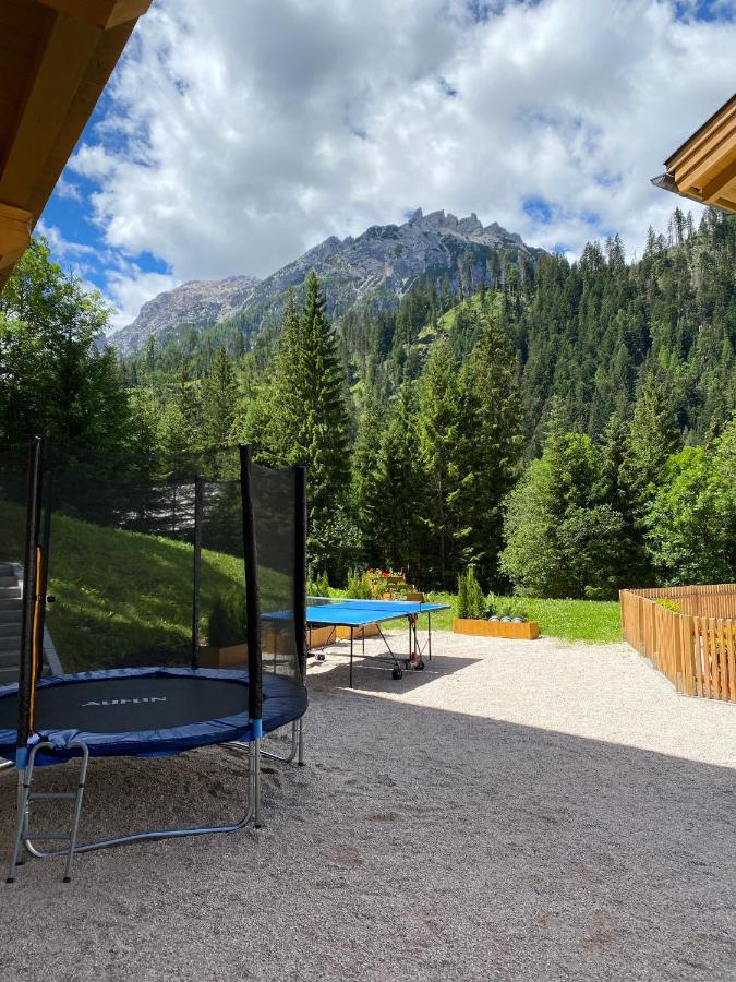 picture of a kids trampoline and a tennis table with mountains in the background