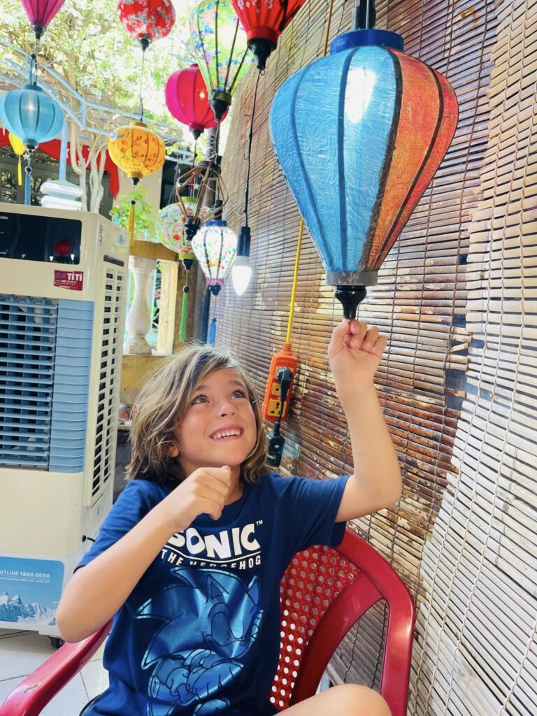 a smiling child holding a Vietnamese lantern