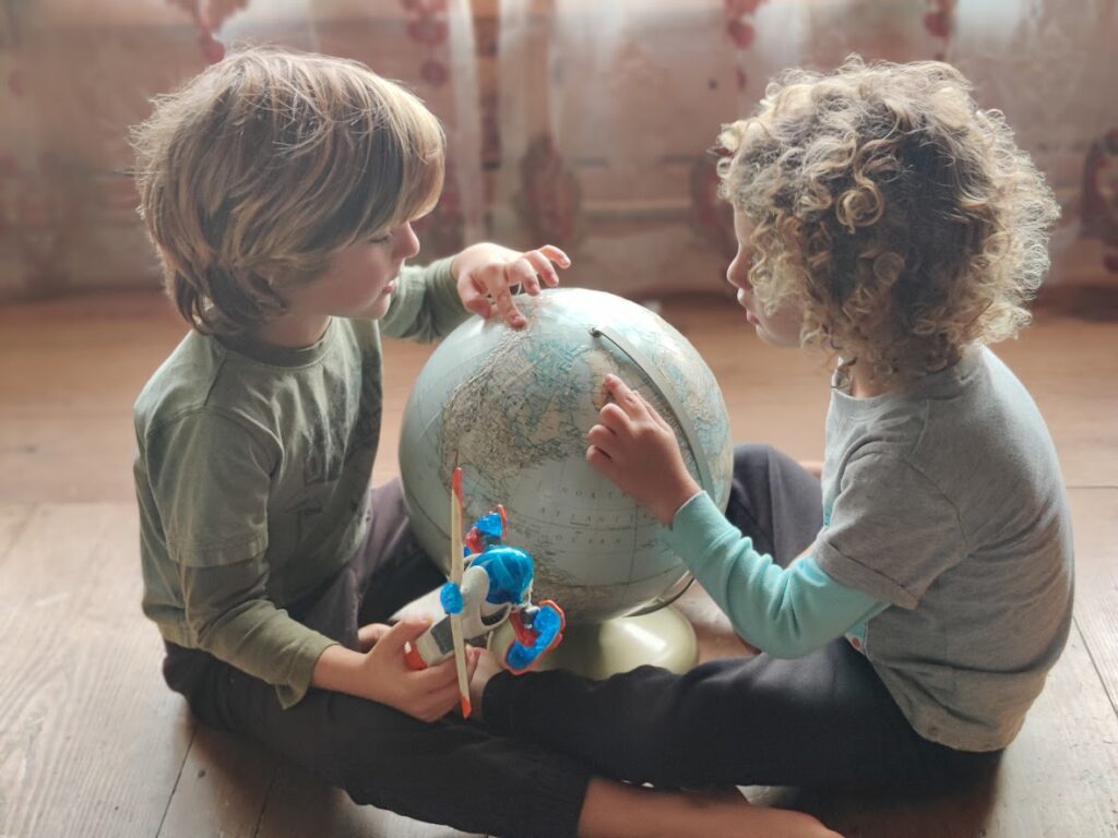 picture of two kids pointing at a globe