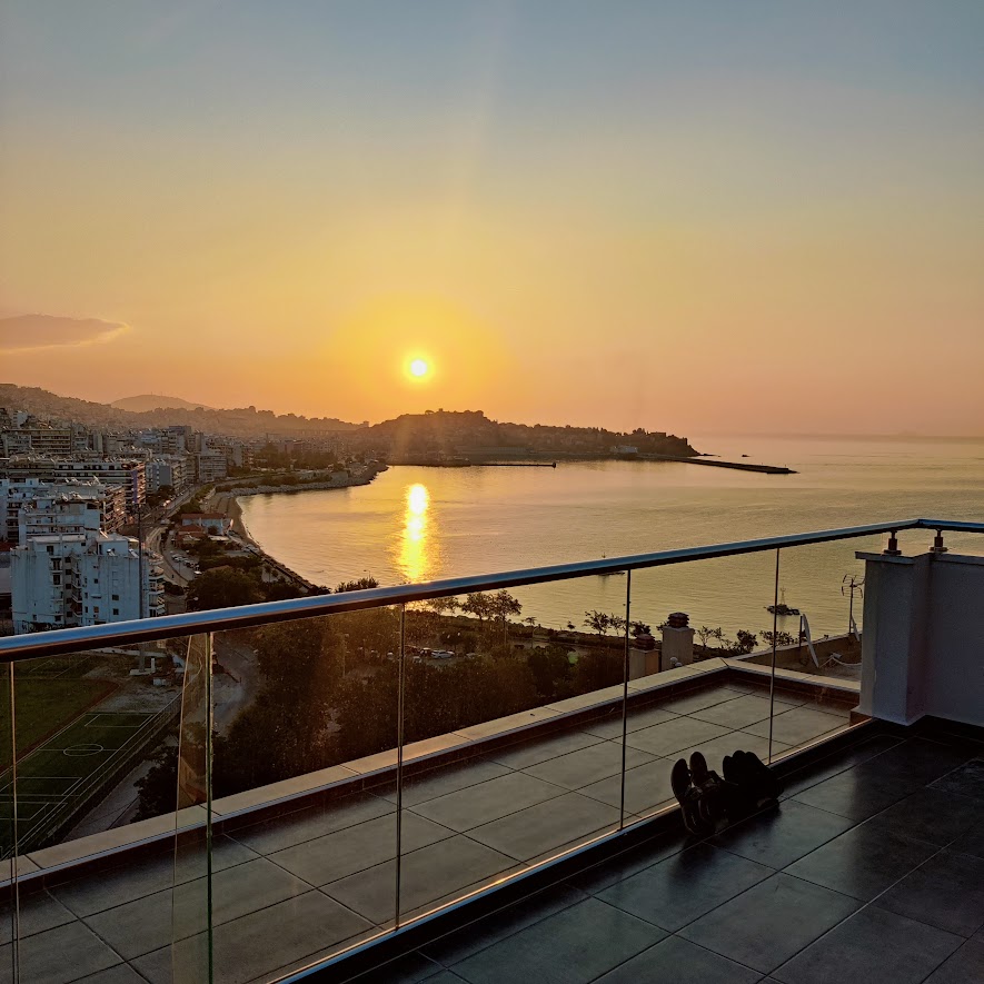 picture of a sunset over the sea and a town