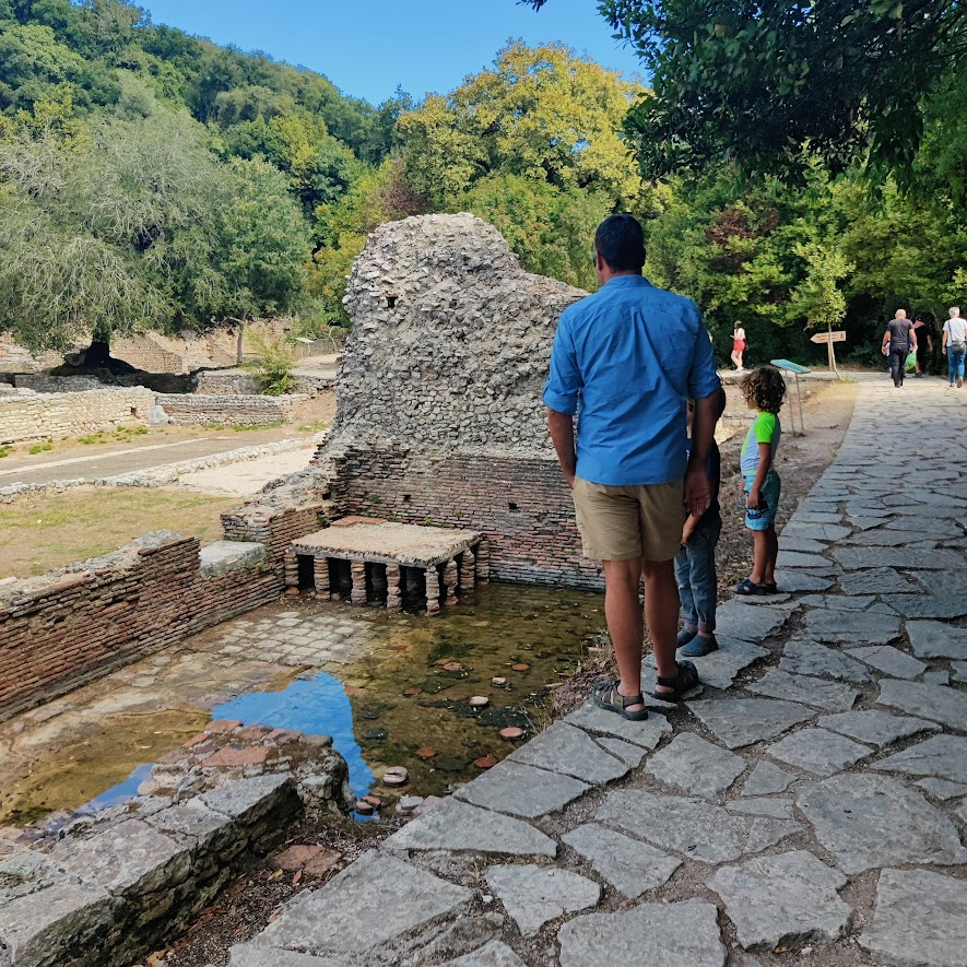picture of a man and children visiting some ruins