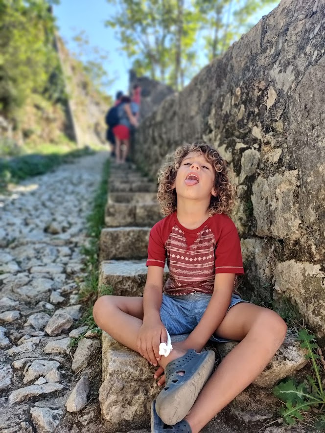 picture of a child sitting on some cobblestone stairs