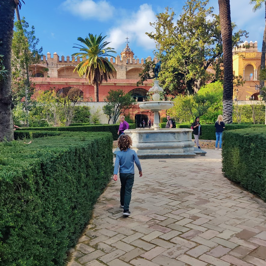 picture of a child walking around some gardens in a Spanish looking place