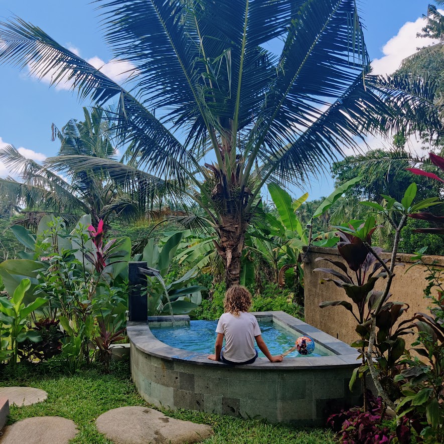 Child sitting on the side of a small pool