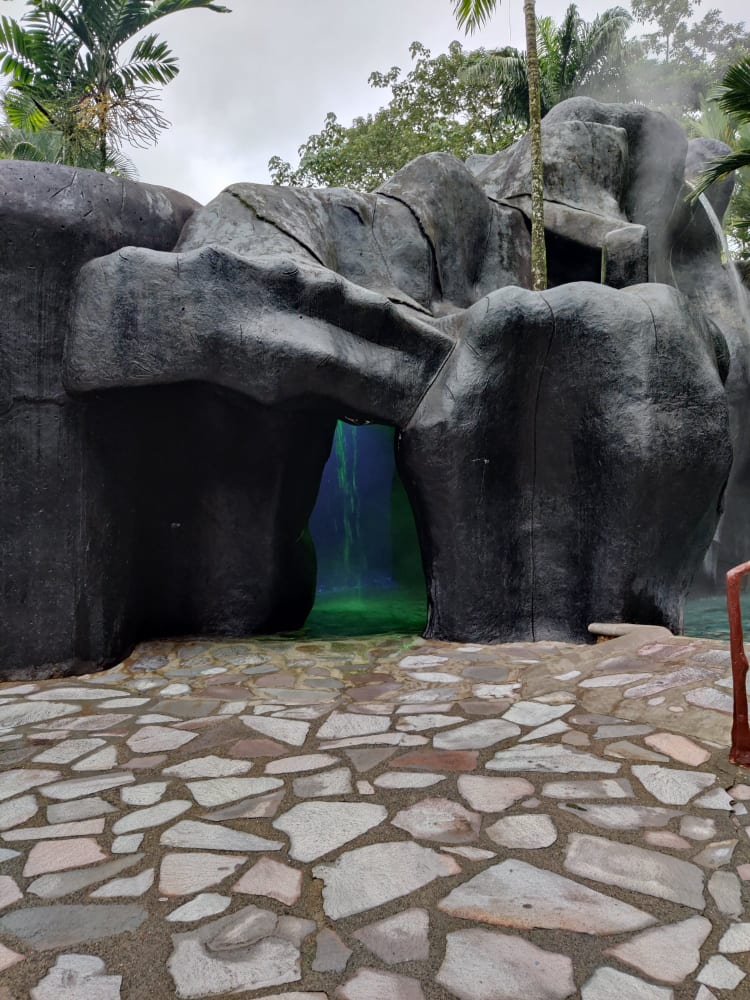 picture of a sauna cave, with a waterfall and green light