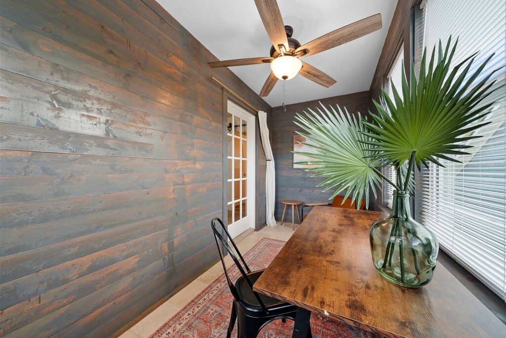 picture of a room with a desk, a plant and a fan