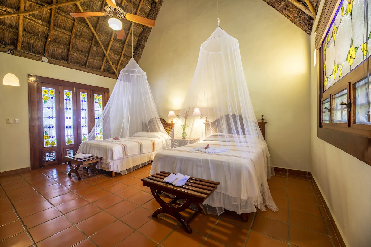 hotel room, with two beds and mosquito nets