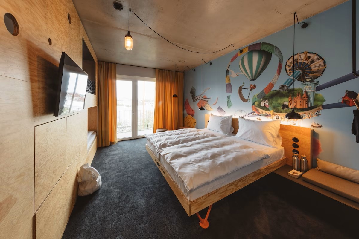 Hotel room with a bed and wall painting showing hot air balloons