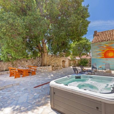 picture of a stone back yard, with a hot tub a table